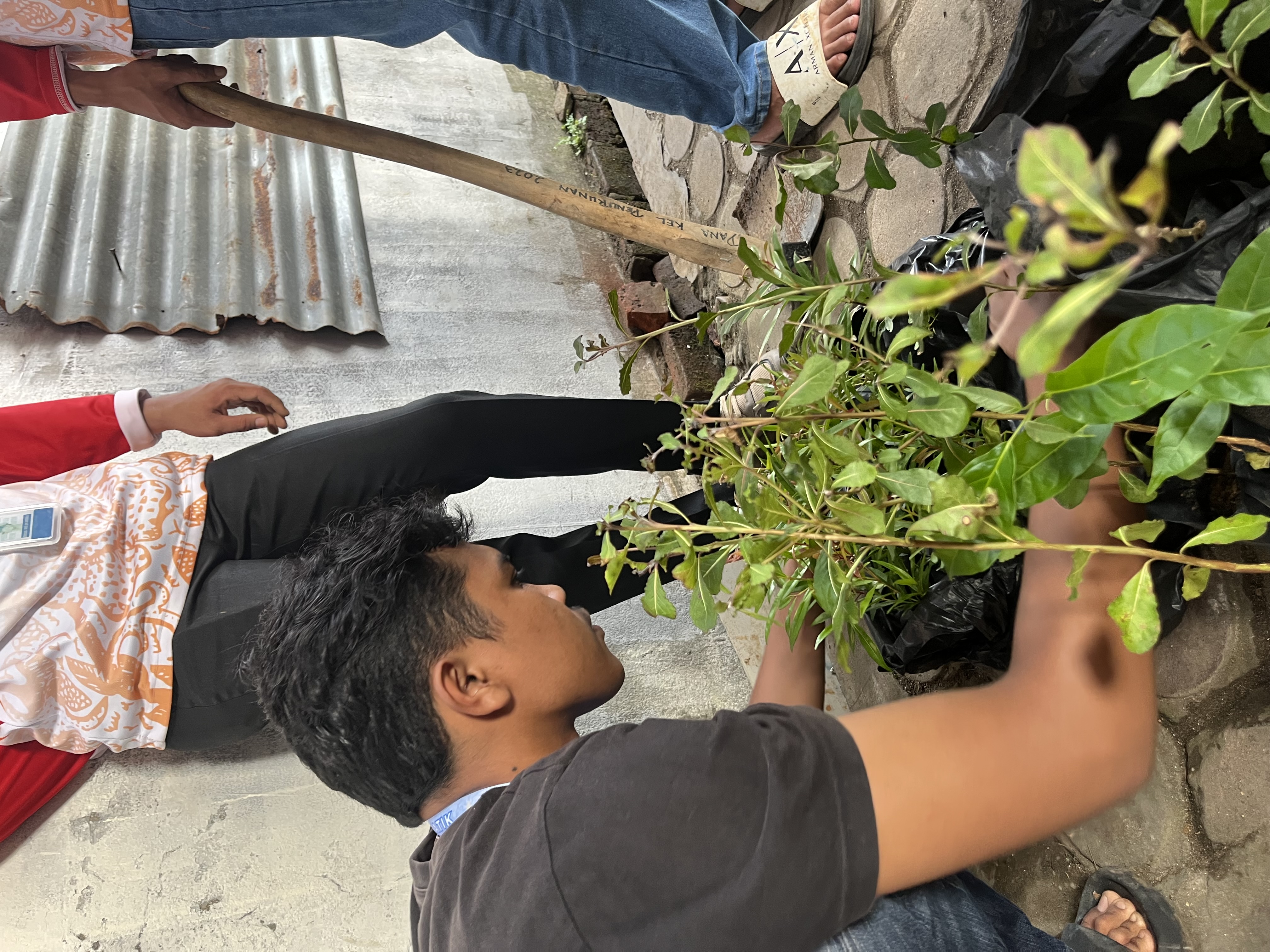 Merapikan bibit bunga untuk di pindahkan ke samping halam posko