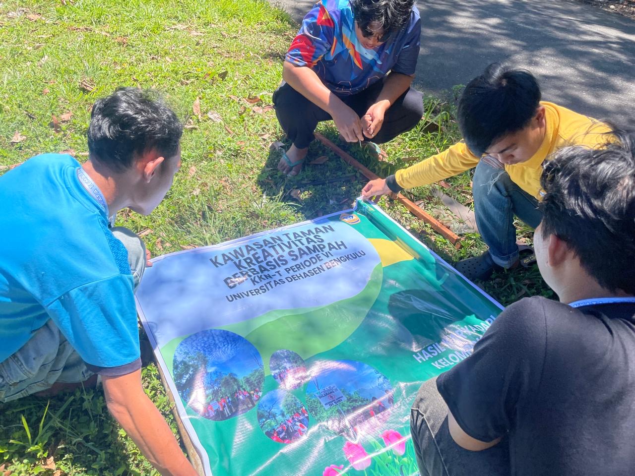 Proses pemasangan kayu ke spanduk  larangan membuang sampah