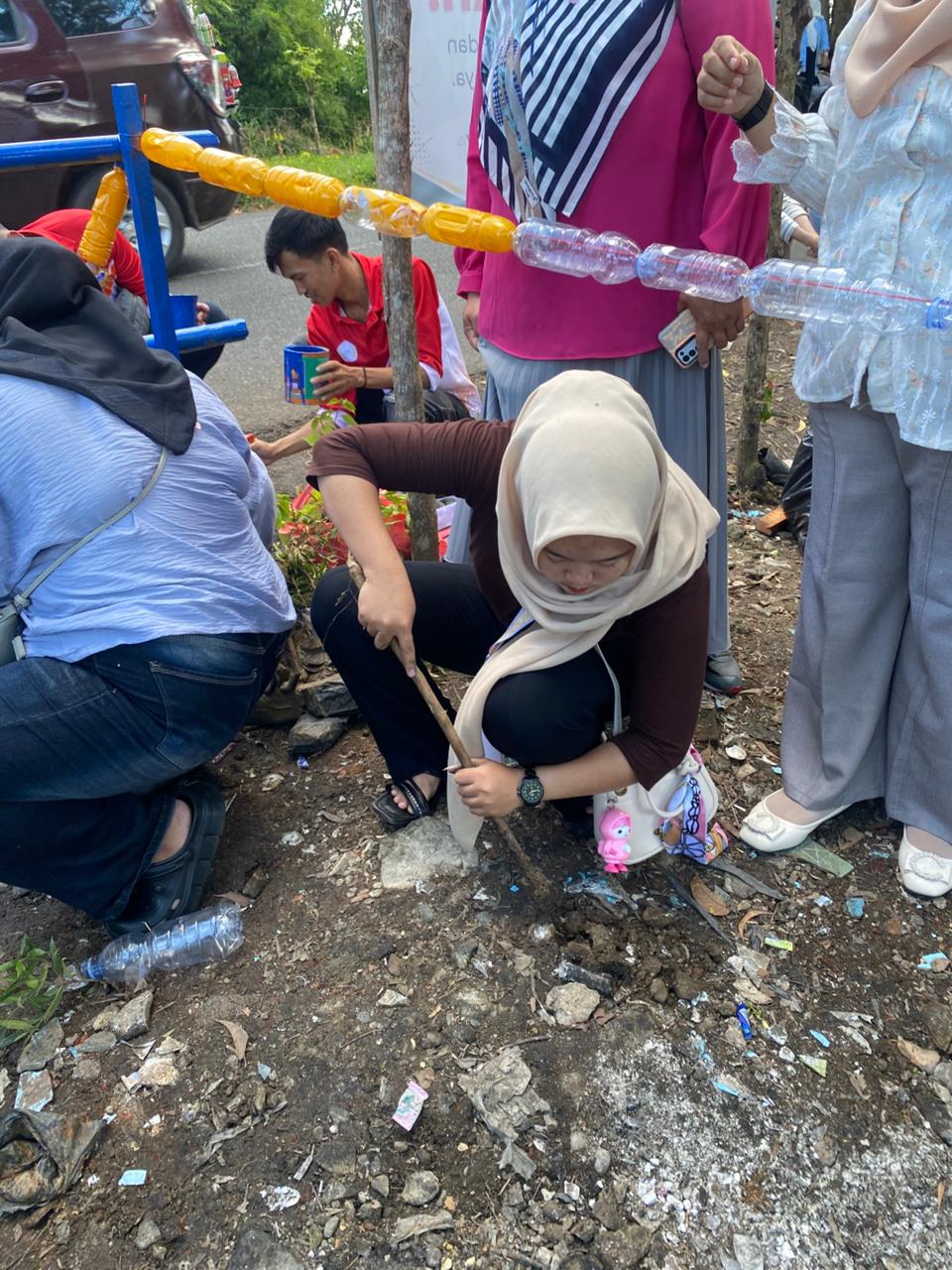 Menggali lobang untuk menanam bibit bunga di taman