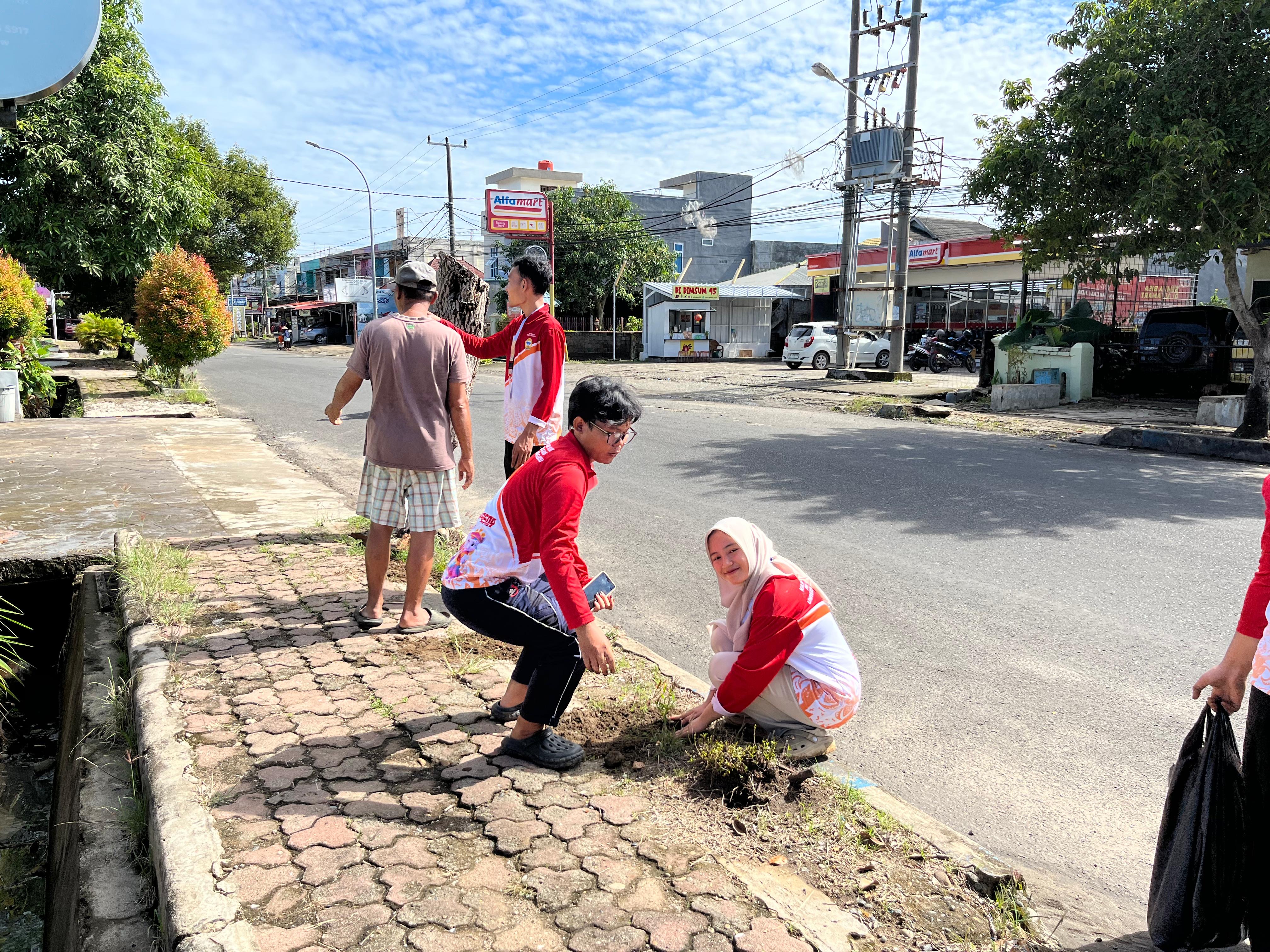 Menanam bibit bunga kedua kali di trotoar jalan rt 10 rw 4 penurunan 