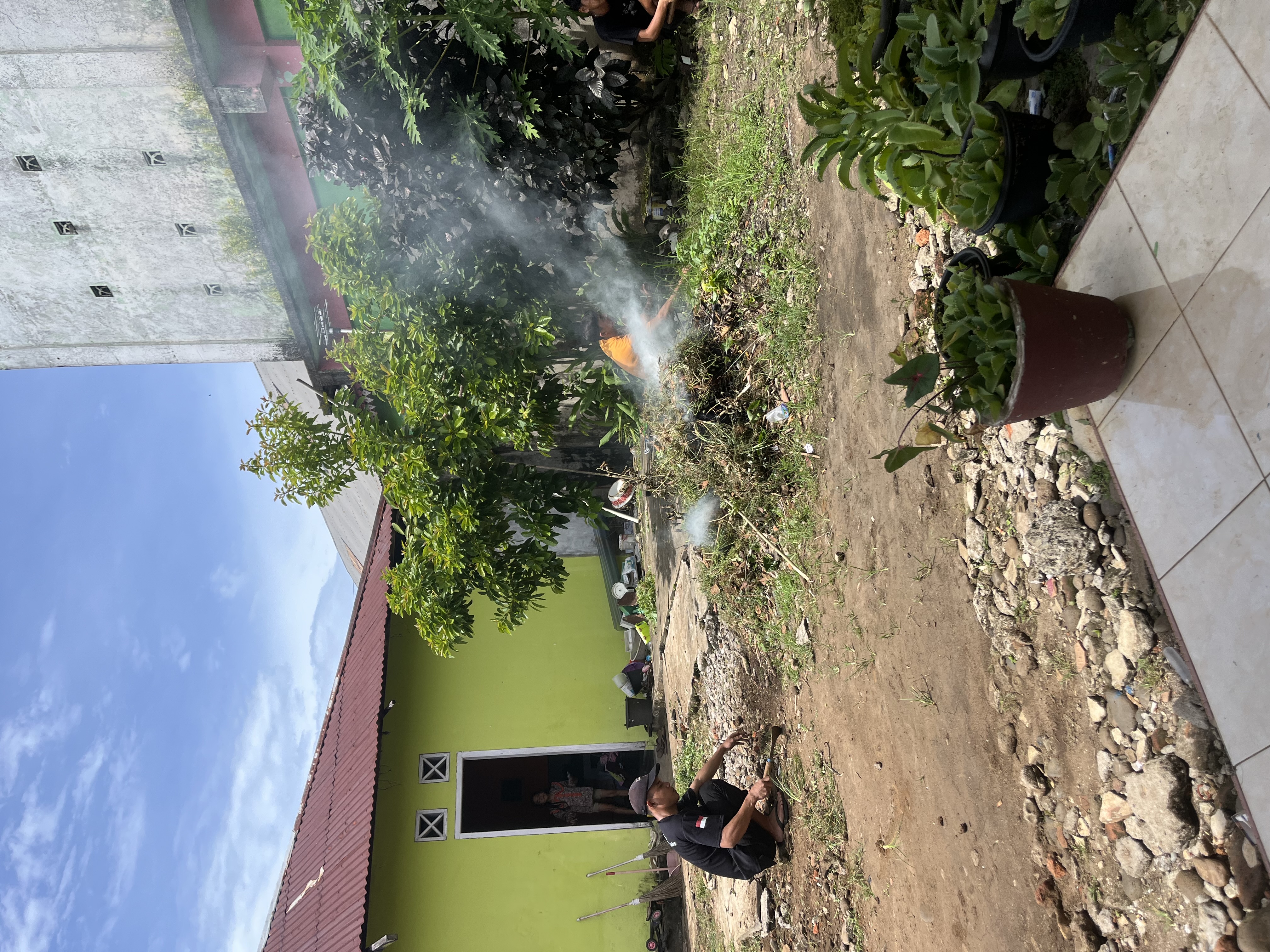 Membersihkan halaman posko kelompok 45