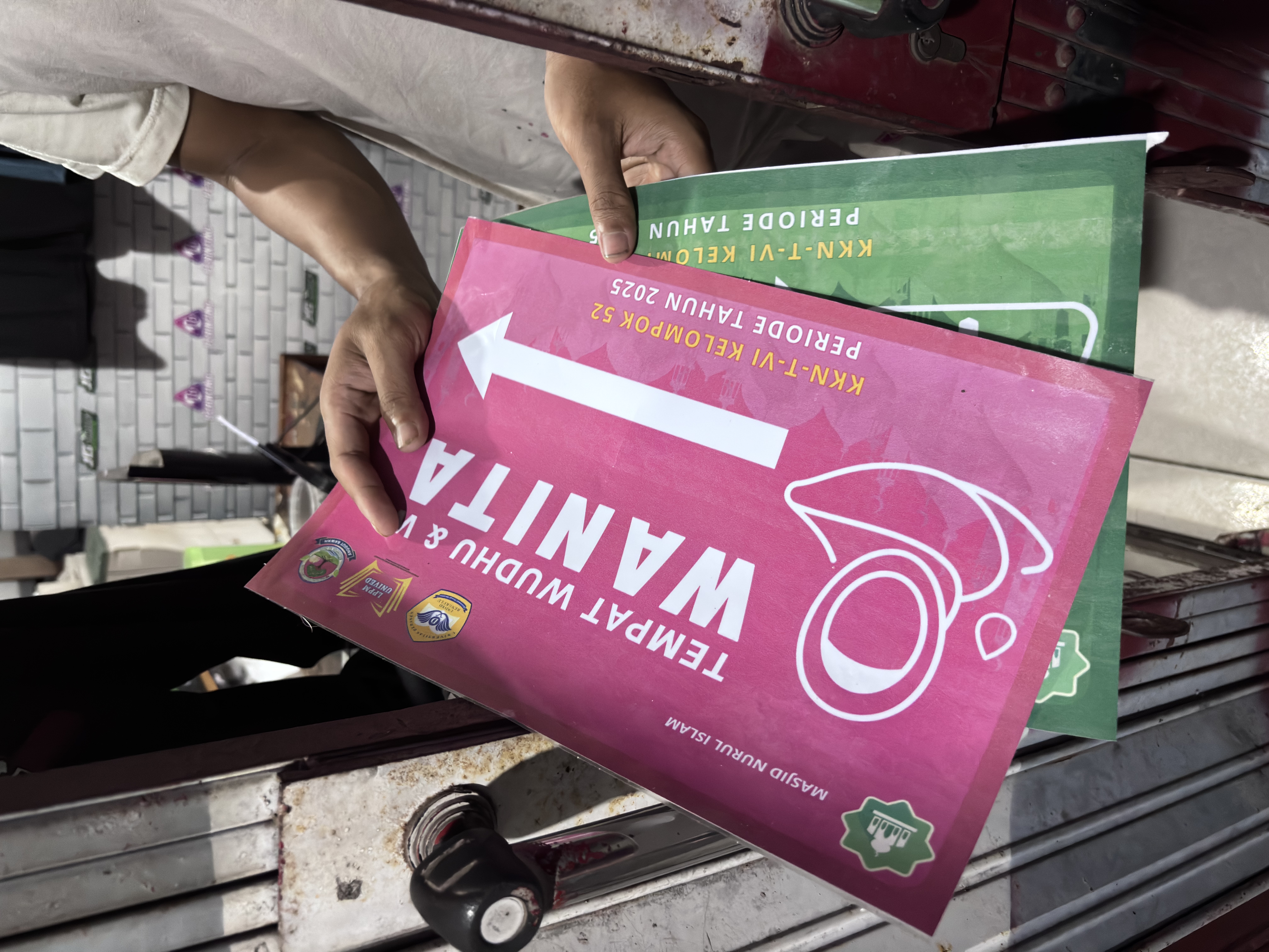 Pembuatan Stiker Informasi Tempat Wudhu dan WC di Masjid Nurul Islam.