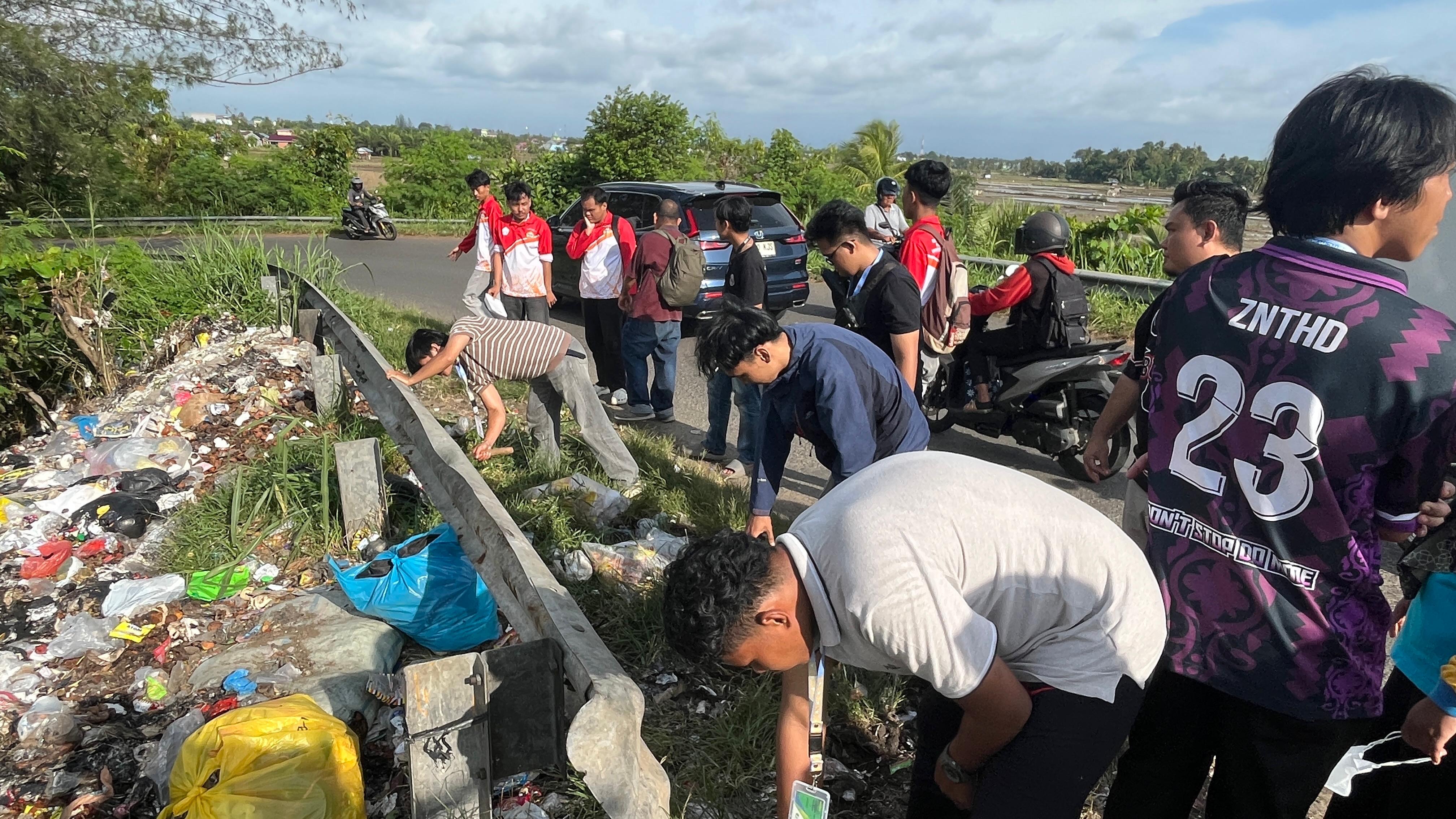 Kegiatan Pembersihan Sampah dan Rumput di Pinggir Jalan Jembatan Kualo sebagai Persiapan Penataan Lingkungan.