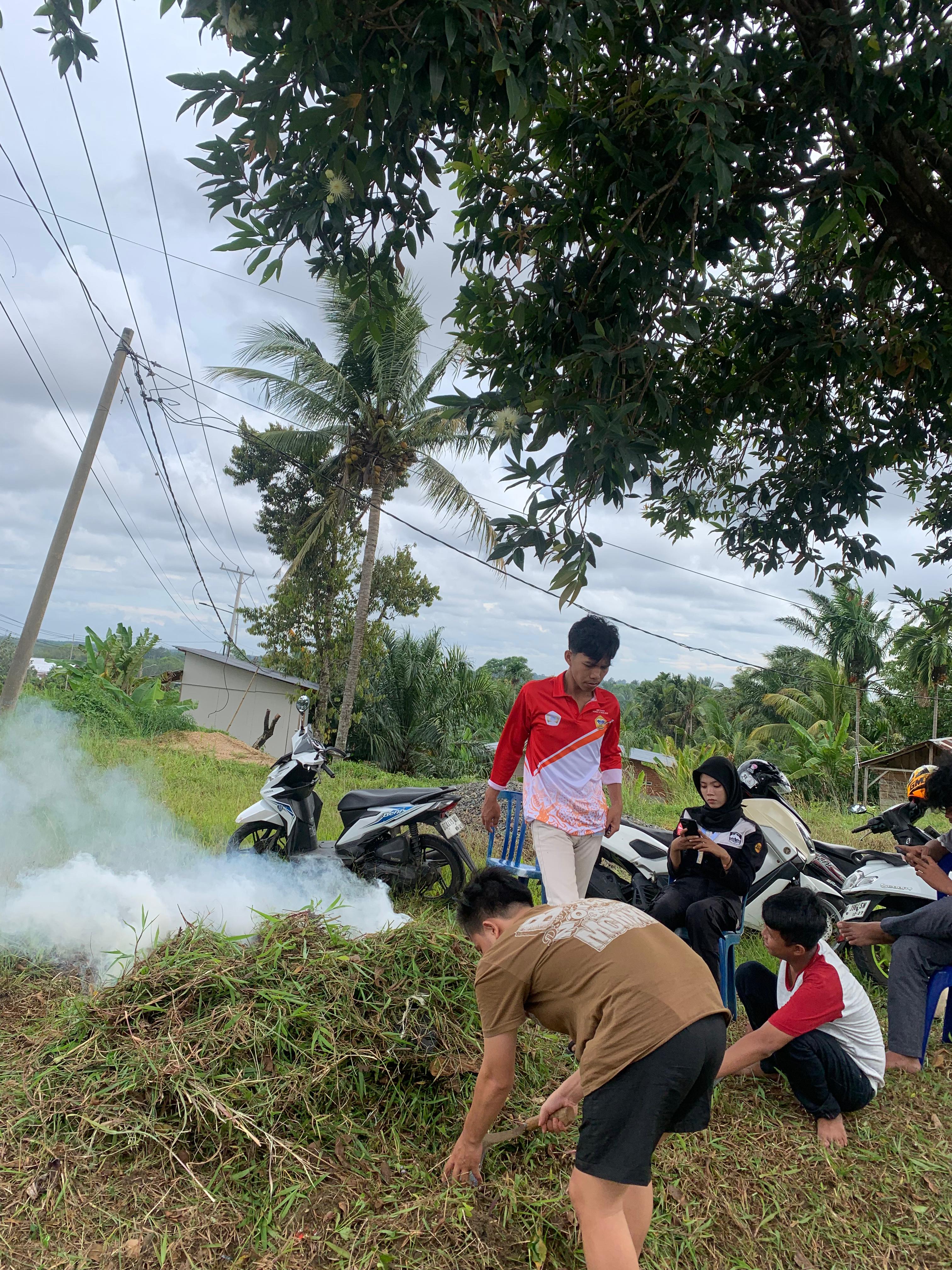 Gotongroyong membersihkan pekarangan posko