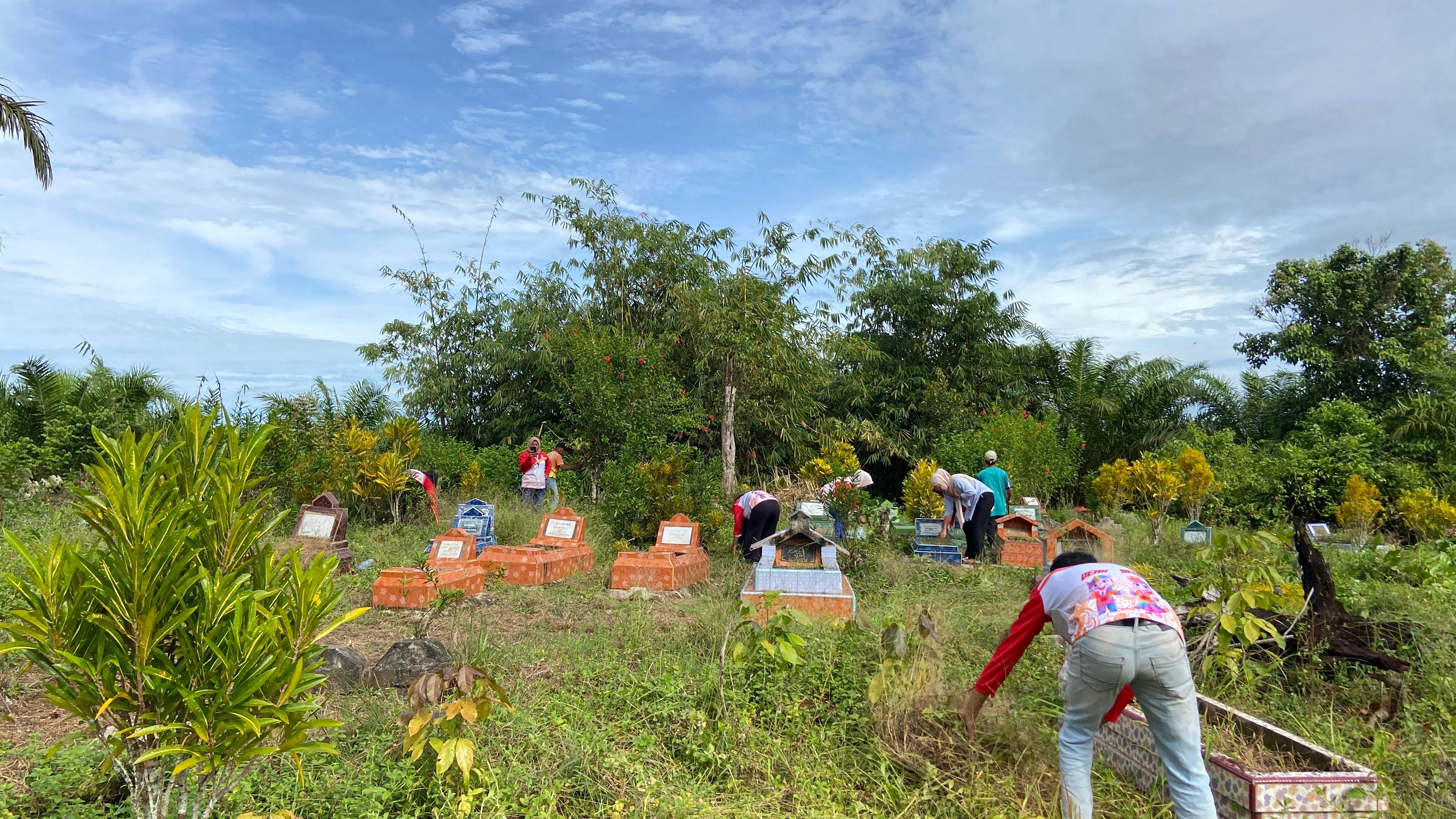 Gotong royong membersihkan area makam