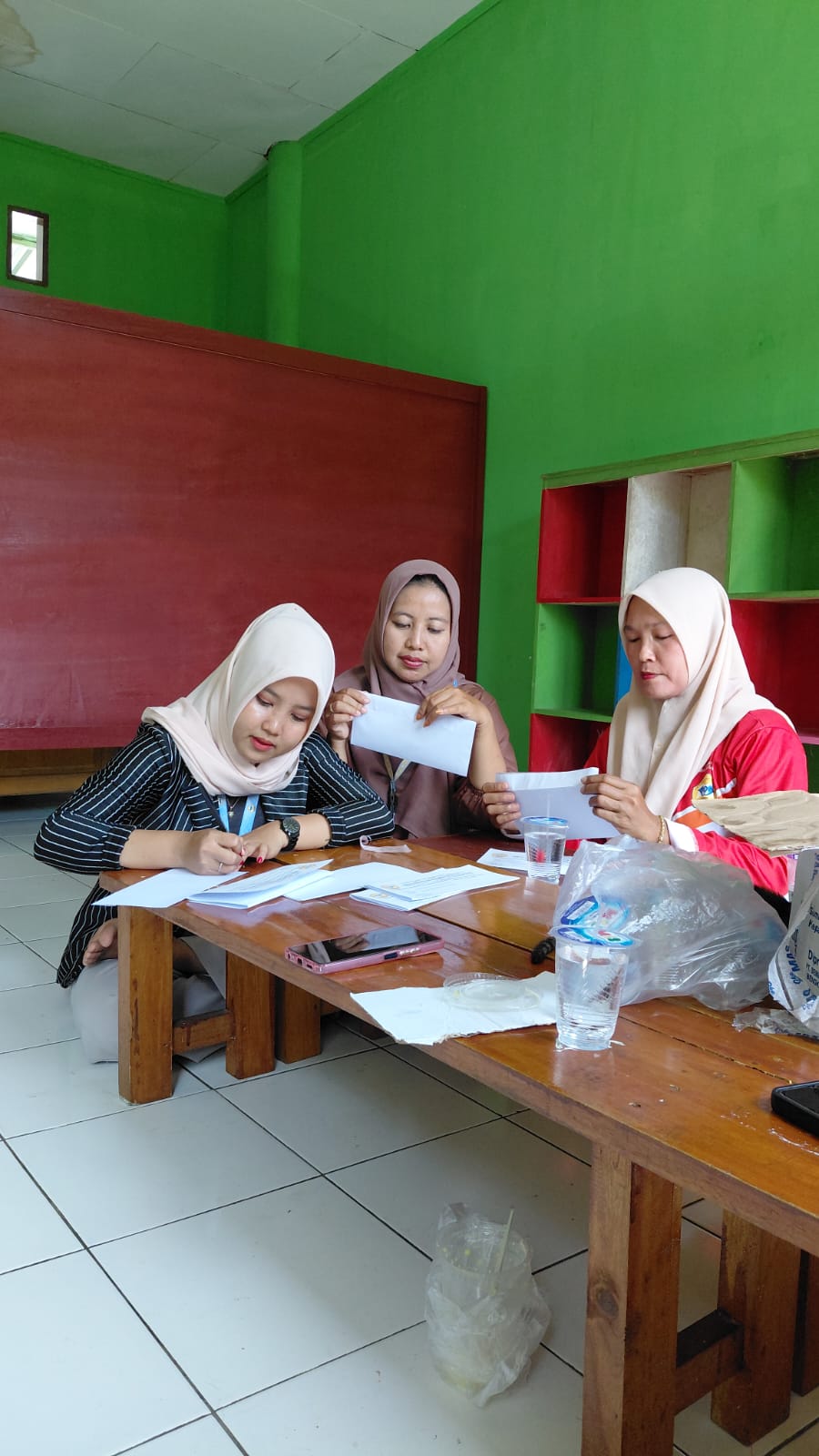 melipat undangan untuk acara penutupan KKN T