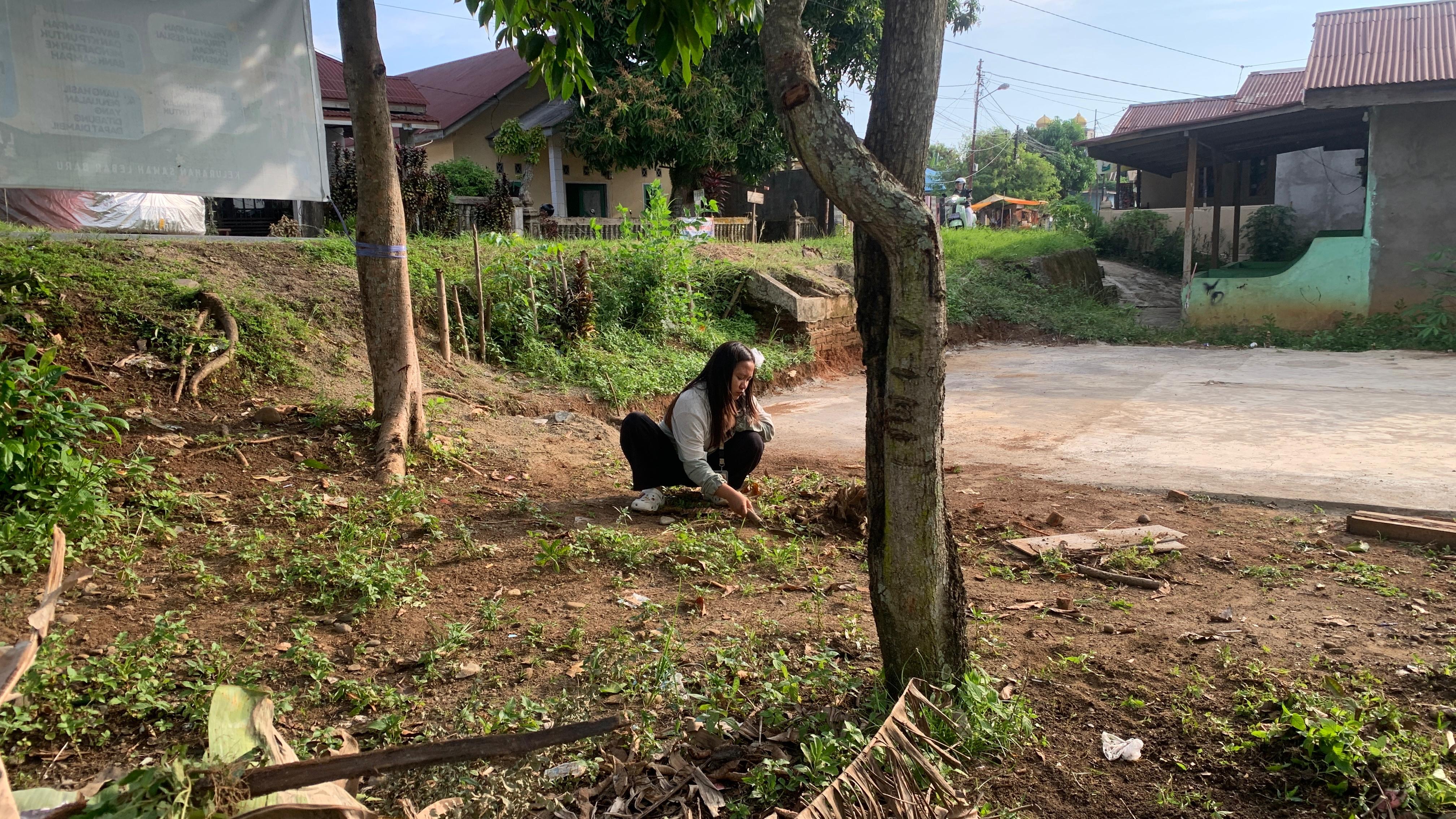 Membersihkan area lapangan RT 22 bersama sama 