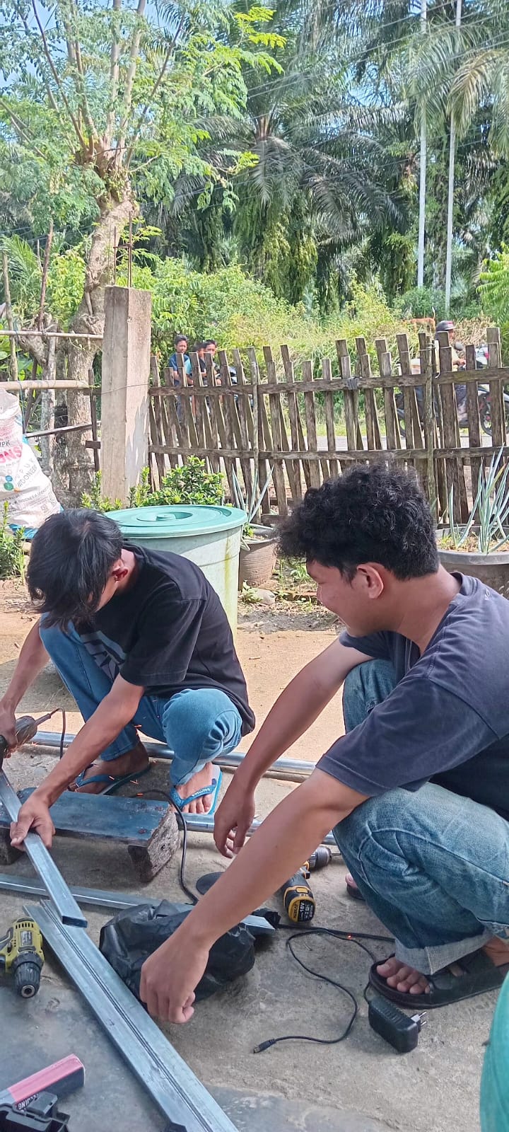 Proses pemotongan besi pembuatan plang pembatas Desa Gelumbang