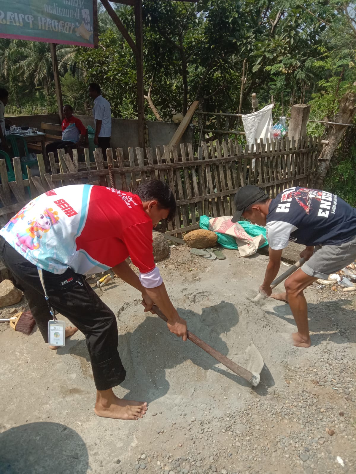 Proses pengadukan semen untuk pemasangan plang pembatas desa