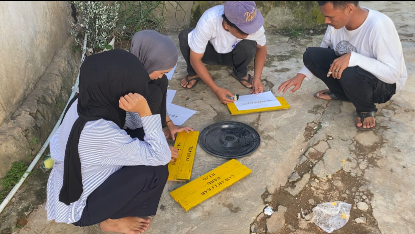kegiatan merakit papan edukasi sampah secara manual.