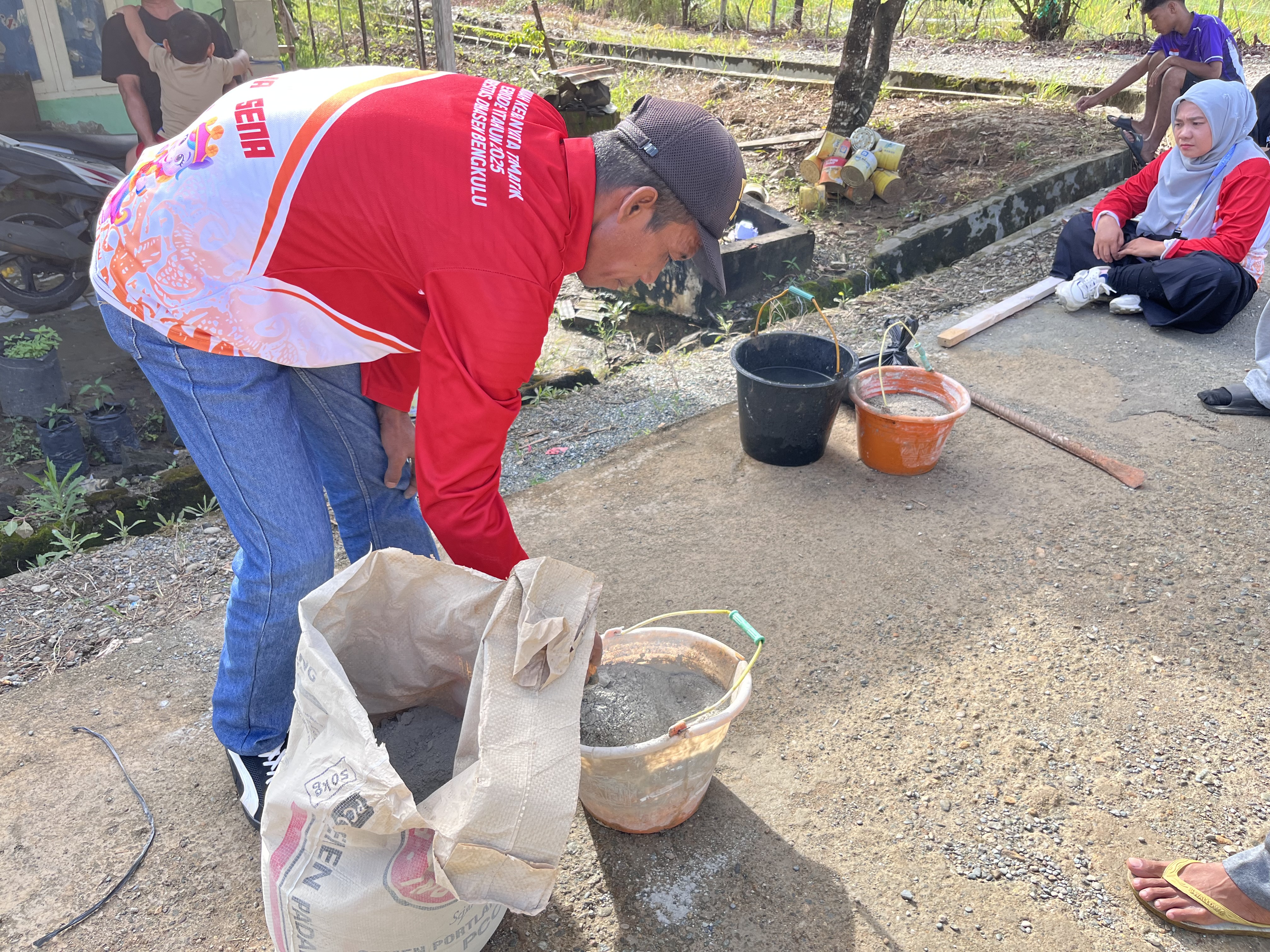 Proses persiapan bahan semen untuk pemasangan plang nama gang