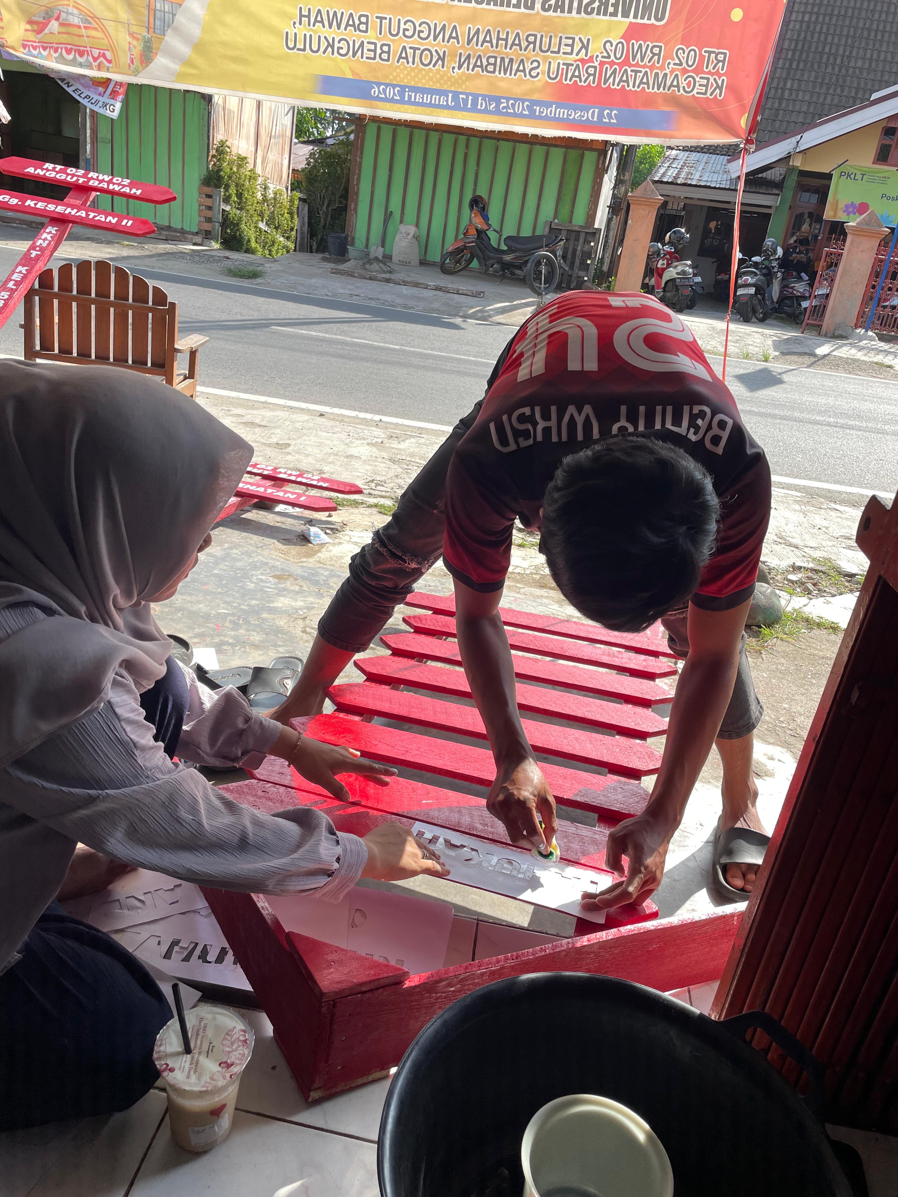 Pengecatan pemberian kata kata di papan edukasi sampah