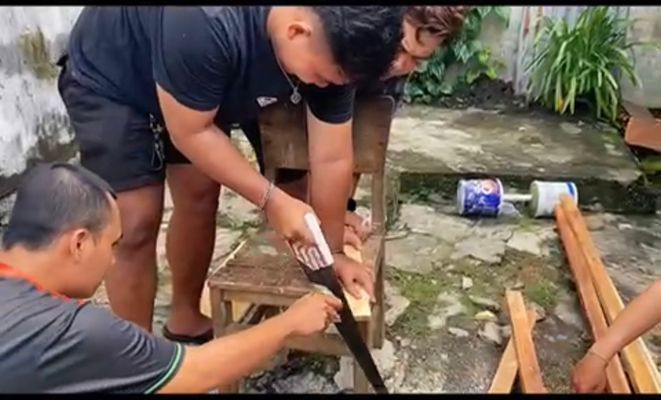 Menggergaji kayu pembuatan tong sampah