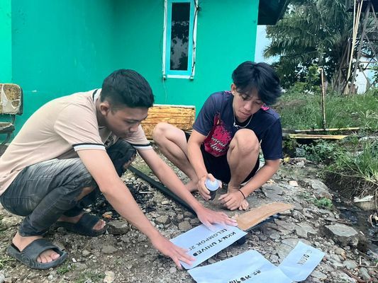 Proses pengecatan papan petunjuk gang RT 29 RW 01 pematang gubernur 